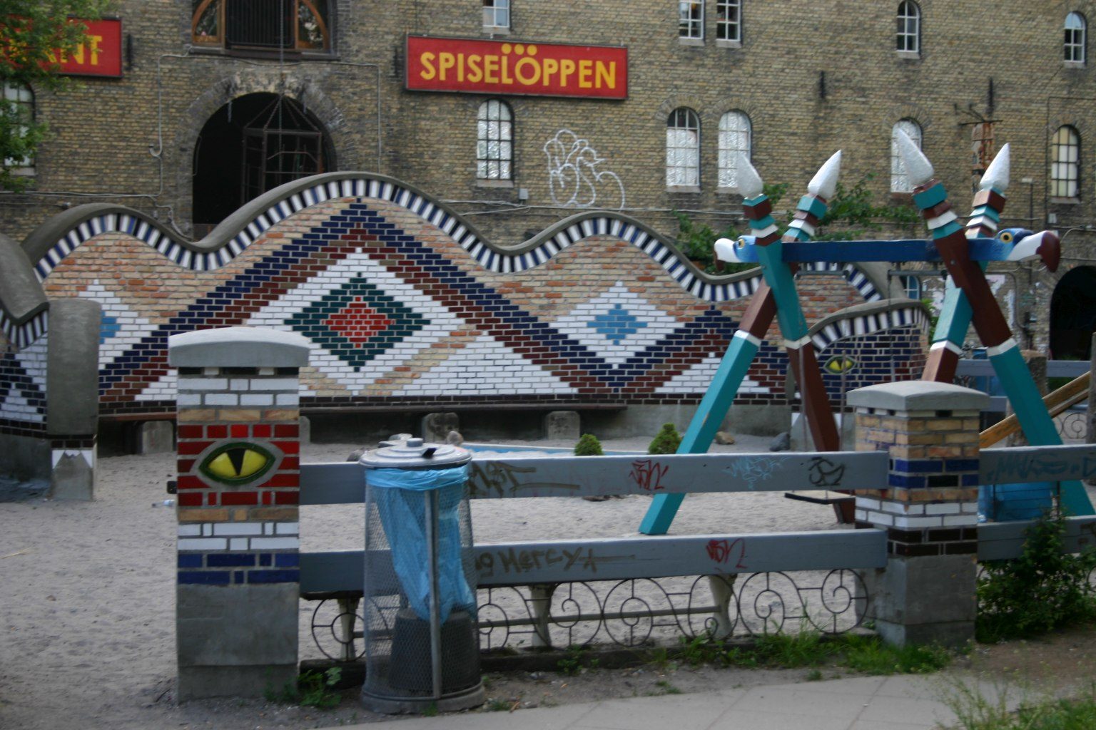 El mural de mosaico de Spiseloppen en Christiania, con esculturas de colores delante