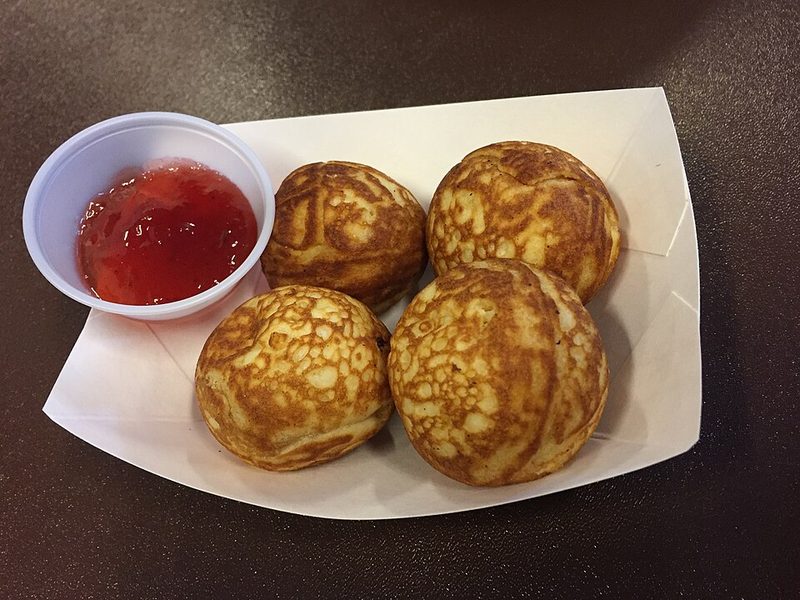Æbleskiver en un cuenco de papel con mermelada roja