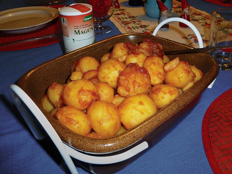 Una fuente de brunede kartofler, patatitas caramelizadas, en una mesa de Navidad