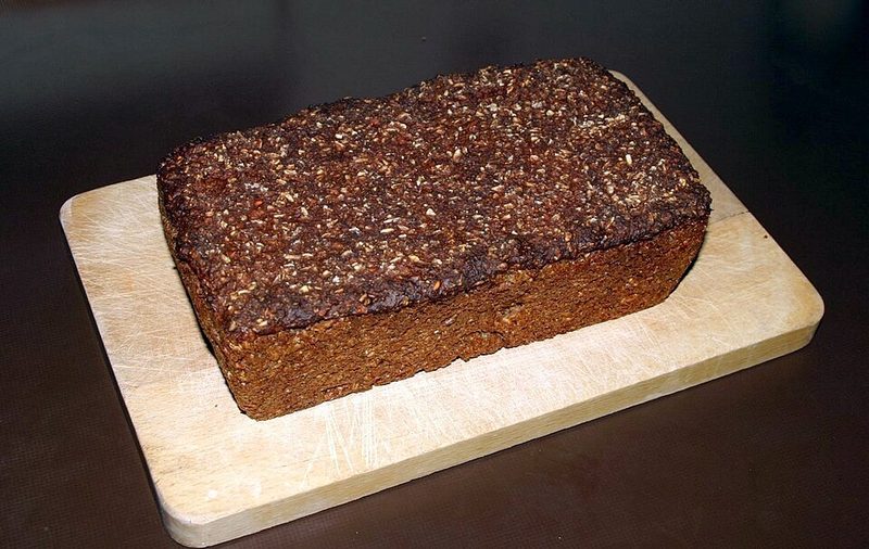 Una hogaza de rugbrød, pan de centeno oscuro con semillas, sobre una tabla