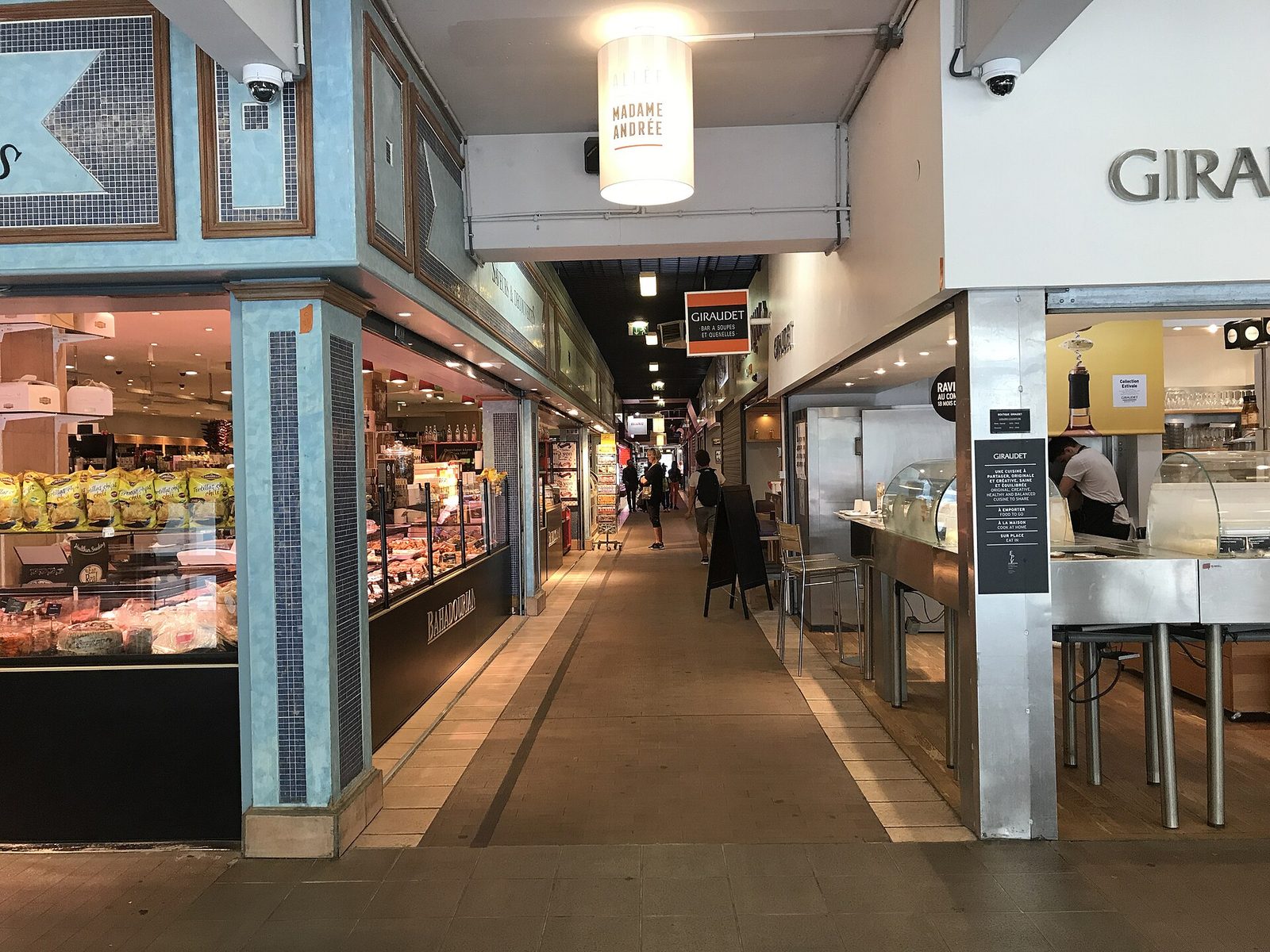 Pasillo interior de las Halles de Lyon Paul Bocuse con sus puestos