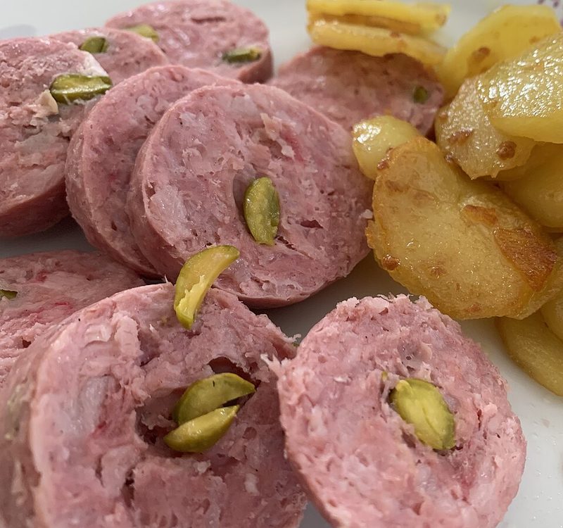 Saucisson chaud con pistachos y patatas salteadas