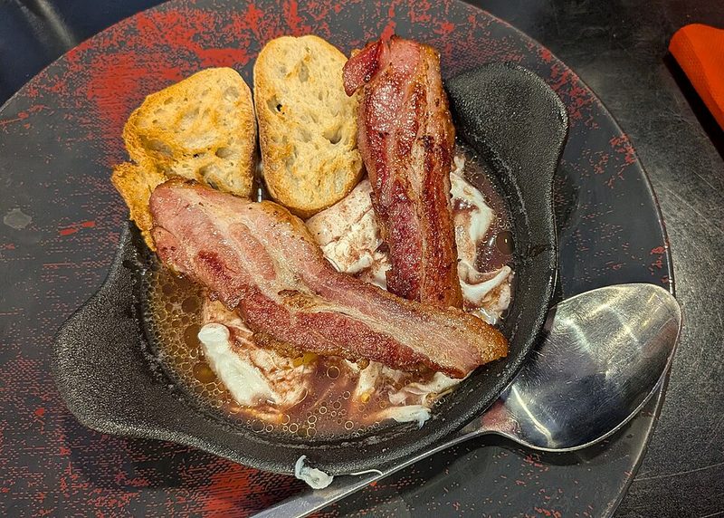 Huevos en meurette con tocino y pan tostado